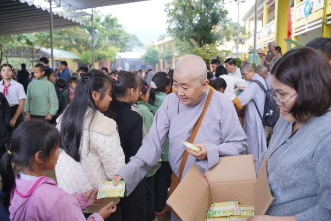 Thành viên đoàn tặng quà bánh cho trẻ em