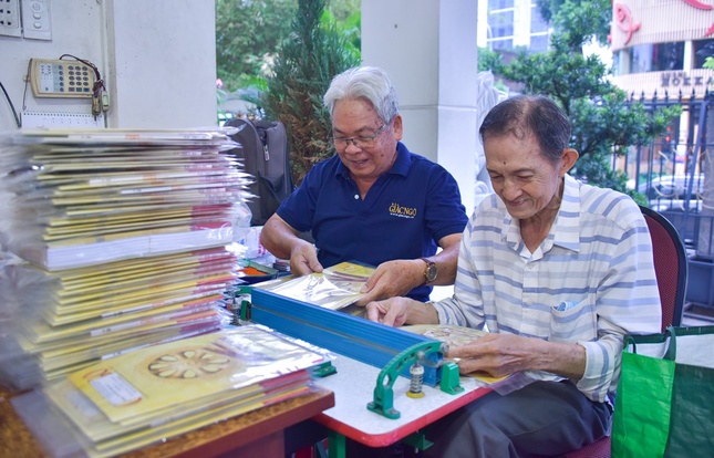 Phật tử Pháp Đức (bên phải ) và Phật tử Pháp Tâm khâu ép bao báo - Ảnh: Quảng Đạo