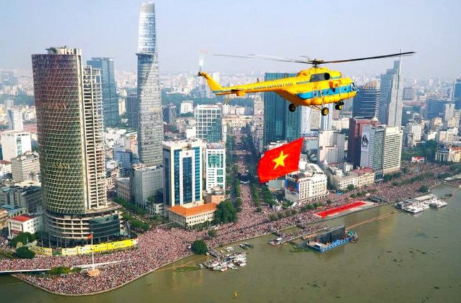 Trực thăng mang cờ Tổ quốc tung bay giữa bầu trời TP.HCM - Ảnh: MTTP