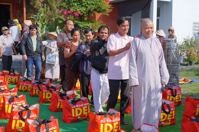 Sư cô Thích nữ Diệu Sơn, trụ trì chùa Long Viên hướng dẫn bà con khiếm thị về chùa nhận quà