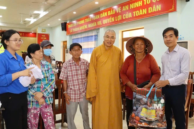 Đại đức Thích Minh Phú, trụ trì chùa Tường Nguyên trao quà đến hộ nghèo - Ảnh: TN