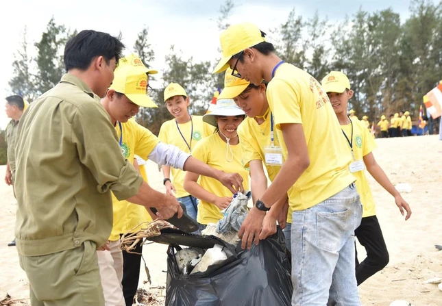 Các bạn trẻ nhặt rác quanh bờ biển xã Đức Lợi - Ảnh: H.N