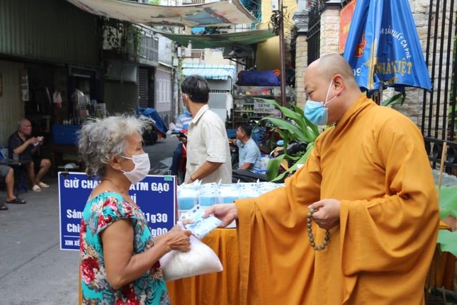 Sau khi nhận gạo người khó khăn được chư tôn đức tặng khẩu trang miễn phí - Ảnh: BĐ