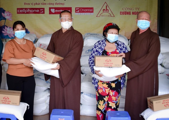 Cô Nguyễn Thị Hoa (đội nón bảo hiểm) nhận quà từ chư tôn đức tại chùa Châu Hưng