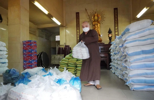 Chư tôn đức phụ vận chuyển các suất quà lên xe chở đến khu cách ly tặng người dân