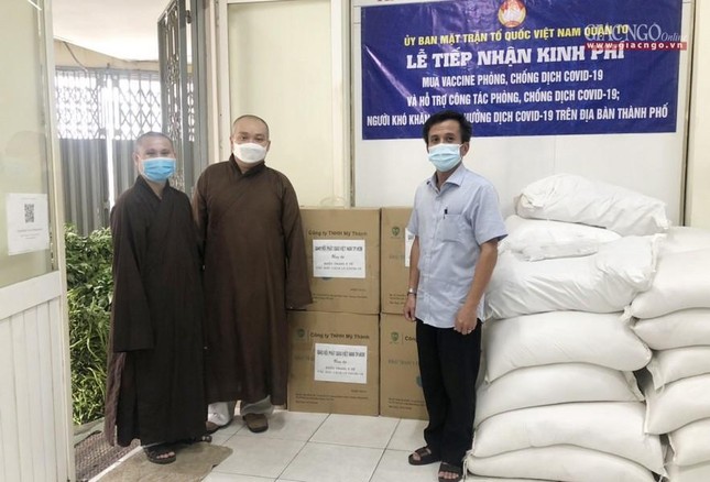 Ông Đoàn Hồng Hiệp, Chủ tịch Ủy ban MTTQVN quận 10 tiếp nhận khẩu trang y tế từ chư tôn đức - Ảnh: TN