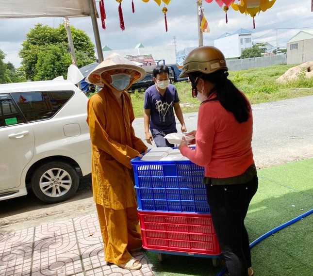 Vận chuyển các suất cơm đến trụ sở Ủy ban Nhân dân phường sau đó có lực lượng chuyên trách chuyển đến lực lượng tuyến đầu - Ảnh: Thiền Giác