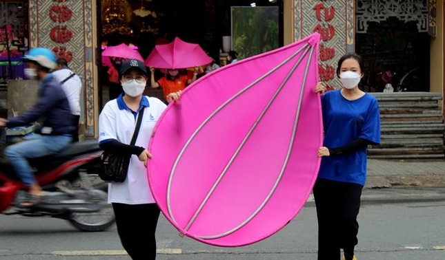 Một cánh sen hồng được bạn trẻ cẩn thận mang ra bờ kênh để lắp ráp