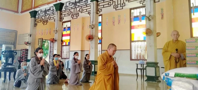 Đại đức Thích Quảng Lực hướng dẫn Phật tử cúng dường trường hạ chùa Xá Lợi, quận 3 - Ảnh: QL