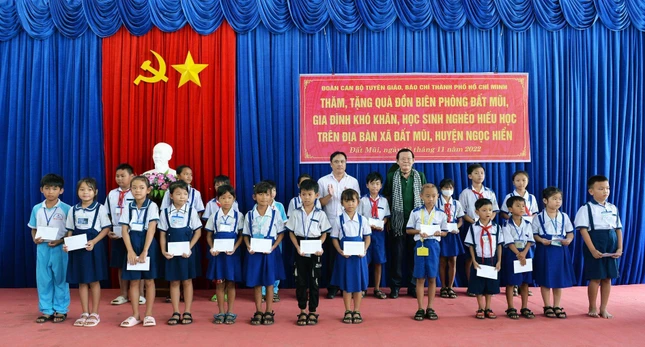 Ông Nguyễn Tấn Phong, Chủ tịch Hội nhà báo TP.HCM cùng đại diện chính quyền trao tặng quà đến các em học sinh - Ảnh: Trần Thế Phong