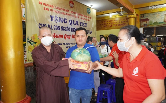 Đại đức Thích Quang Hạnh, trụ trì chùa Như Lai, cùng đại diện Hội chữ Thập đỏ quận Gò Vấp hỗ trợ người khiếm thị đến nhận quà