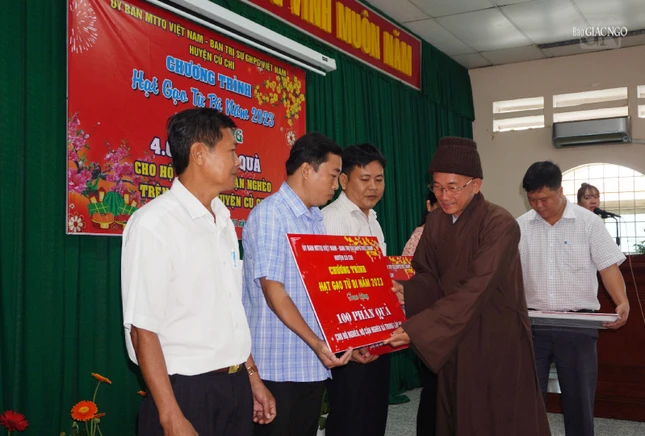 Thượng tọa Thích Tịnh Tâm, Phó ban kiêm Chánh Thư ký Ban Trị sự GHPGVN huyện trao biển tượng trưng các phần quà đến đại diện các xã