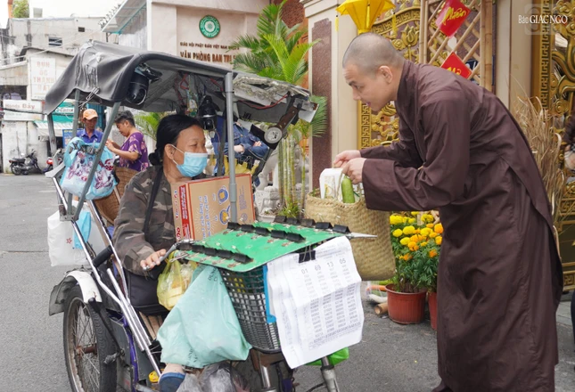 Đại đức trụ trì chùa Minh Đạo ân cần hỏi thăm trao tặng quà đến người khuyết tật, bán vé số