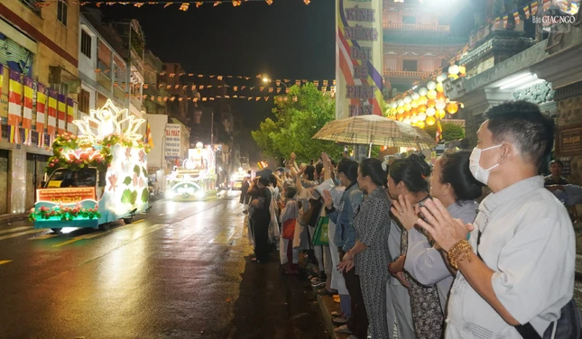 Phật tử Diệu Nhường (người thứ 2 từ bên phỉa màn hình) cũng Phật tử chùa Ấn Quang chắp tay khi đoàn xe diễu hành đi qua