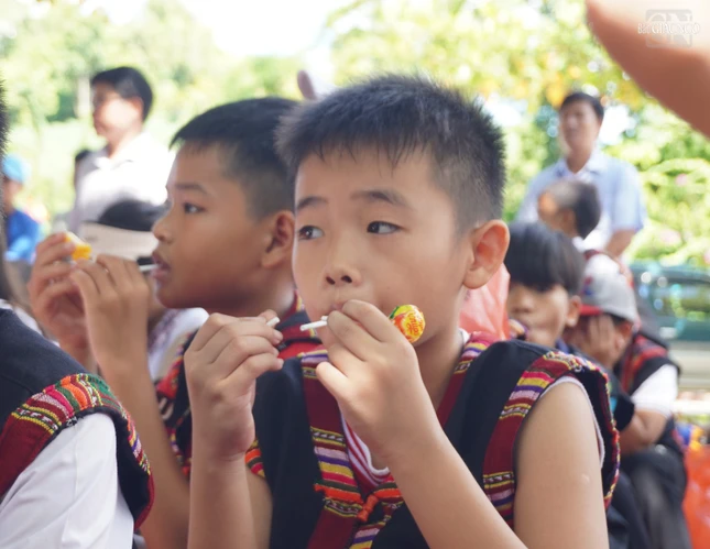 Những quà bánh vừa được tặng các em đã mang ra thưởng thức