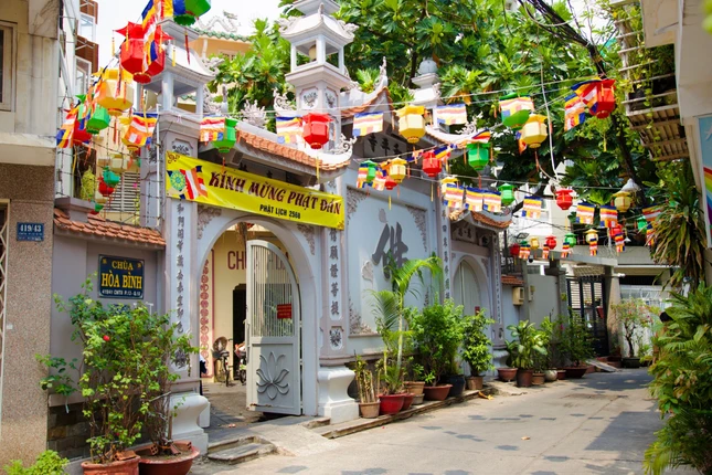 Cờ, lồng đèn kính mừng Phật đản được treo trước chùa Hòa Bình, Q.10