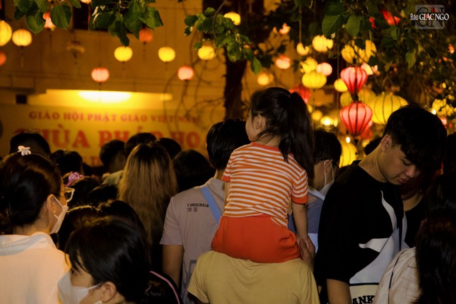 Em bé được cõng trên lưng người thân dự lễ