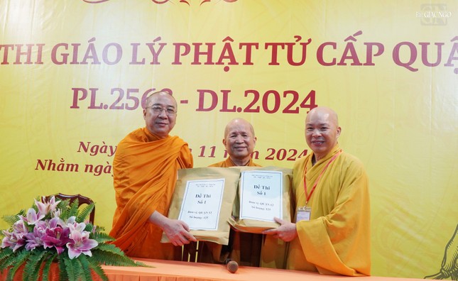 Thượng tọa Thích Giác Tín, Thượng tọa Thích Thiện Hạnh, Phó ban Tổ chức Hội thi giáo lý Phật tử trao đề thi đến Thượng tọa Thích Trí Thường, Trưởng ban Trị sự GHPGVN Q.12