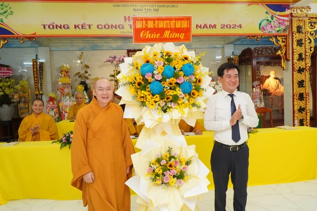 Ông Huỳnh Gia Giang, Chủ tịch UBMTTQVN Q.3 trao lẵng hoa chúc mừng của chính quyền quận