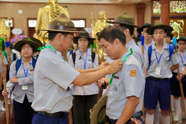 Huynh trưởng cấp Tấn Tâm Dũng - Nguyễn Hữu Tiến, Phó Phân ban Gia đình Phật tử TP.HCM kiêm Ủy viên Nghiêm huấn Khu vực I trao quyết định và còi lệnh đến Huynh trưởng cấp Tín Quảng Từ - Ngô Văn Mẫn, Trại trưởng Liên trại huấn luyện tại chùa Giác Nguyên