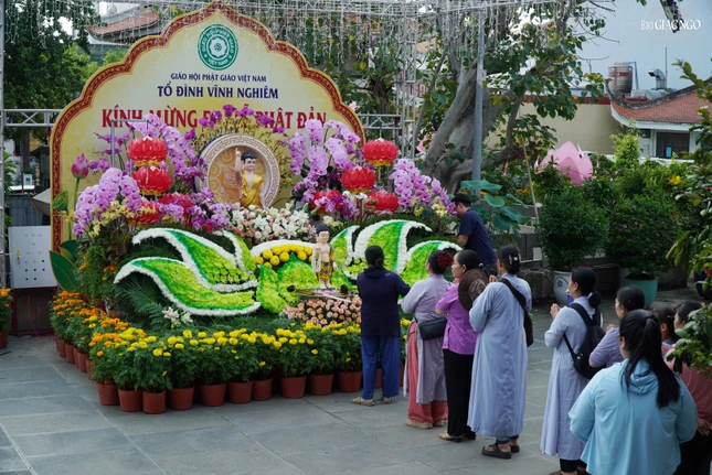 Phật tử trang nghiêm thực hiện nghi thức Tắm Phật tại tôn tượng Phật đản sanh được thiết trí trước sân chánh điện tổ đình Vĩnh Nghiêm