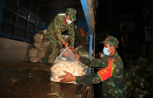 Các chiến sĩ hỗ trợ đưa 9 tấn rau từ xe tải xuống đường