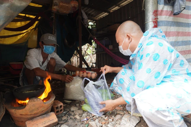 Những suất quà có 5 ký gạo, và trái bí, trái bầu, hộp trứng nhưng đem đến cho người dân sống ở khu bãi rác này nhiều niềm vui, hạnh phúc. Ảnh: Như Danh/BGN