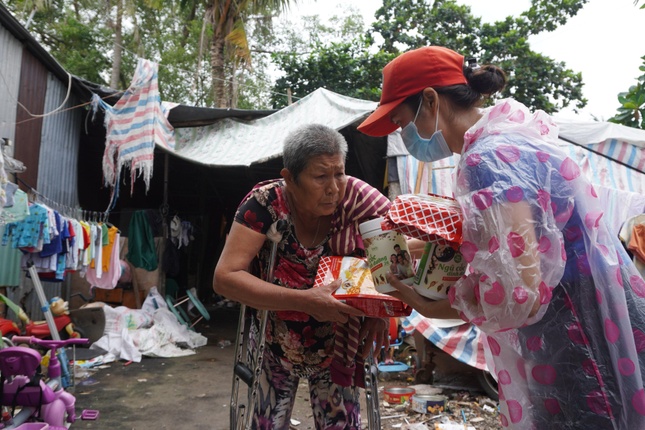 Chị Thảo Nguyên (phải), tác giả bài viết “Nhật ký một tình nguyện viên: Dọn lòng tinh tươm đón nắng mới…” đăng trên báo Giác Ngộ, quay trở lại thêm lần nữa với người dân khu bãi rác khắc khổ. Ảnh: Như Danh/BGN