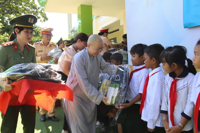 Ni sư Thích nữ Huệ Dâng ân cần trao quà đến các em học sinh