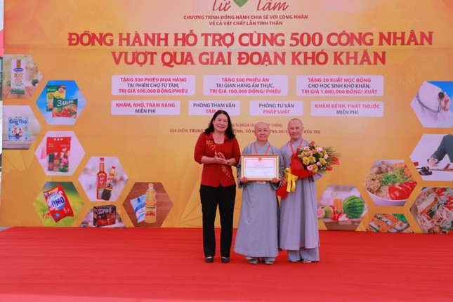 Bà Nguyễn Thị Bé Mười, Phó Chủ tịch Ủy ban Nhân dân tỉnh trao Bằng khen và hoa đến Ni sư Thích nữ Huệ Dâng