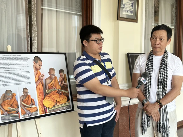 Nhiếp ảnh gia Trần Thế Phong trả lời phỏng vấn báo chí trong triển lãm sáng nay, 1-8