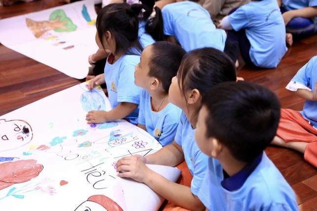 Em chăm chú lắng nghe hướng dẫn của anh chị để vẽ bức tranh đẹp nhất gửi đến ba mẹ