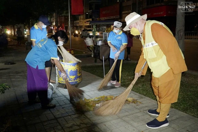 Thành viên đoàn cẩn thận quét sạch vỉa hè, nơi có nhiều lá cây rơi rụng trong đêm