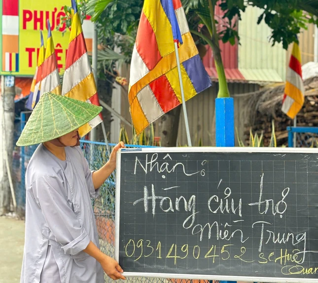 Nơi cổng chùa, một tấm bảng với dòng chữ ngắn "Nhận hàng cứu trợ miền Trung" được dựng lên, nhưng ai đọc rồi cũng ghi nhớ, "để lòng" và lưu tâm - Ảnh: Huệ Quang