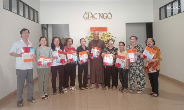 Đại đức Thích Quảng Hậu, Chủ nhiệm Câu lạc bộ Phóng viên - Cộng tác viên Báo Giác Ngộ trao cờ Phật giáo đến Phật tử, tại trụ sở tòa soạn