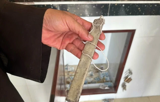 Đối tượng dùng 1 cây mỏng có dán băng keo 2 mặt, buộc vào sợi dây rồi đưa vào thùng công đức để trộm tiền - Ảnh: Huệ Trí