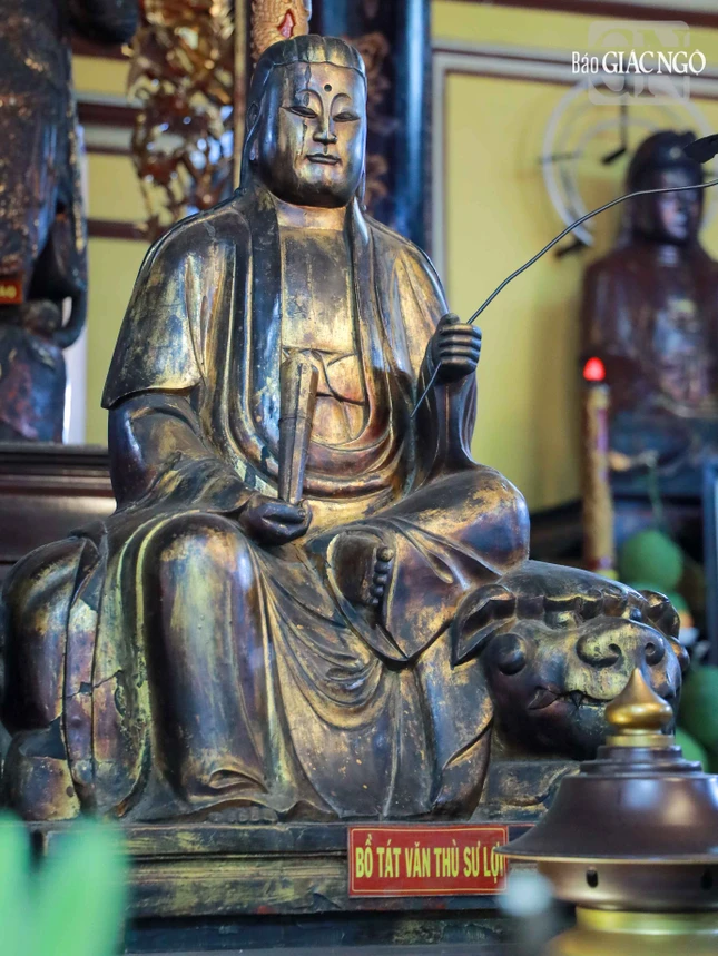 Văn Thù Bồ-tát tay cầm nhành như ý, ngồi trên lưng sư tử