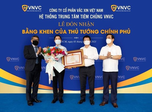Thứ trưởng Bộ Y tế Trương Quốc Cường (thứ 2 từ phải qua) thay mặt Chính phủ và Bộ Y tế trao tặng bằng khen cho ông Ngô Chí Dũng, Chủ tịch Hội đồng Quản trị kiêm Tổng giám đốc Công ty Cổ phần Vacxin Việt Nam (thứ hai từ trái qua) - Ảnh: Phong Lan.