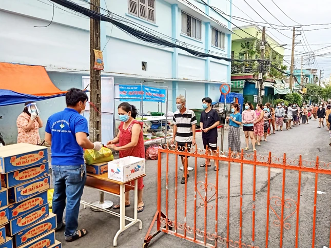 Người dân xếp hàng ngay ngắn, giãn cách đợi nhận quà của chùa Giác Quang