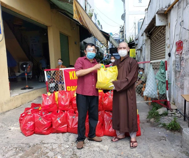 Đại đức Thích Chơn Tâm gửi quà cho đại diện nhóm phân phát quà đến người dân tại khu vực phong tỏa
