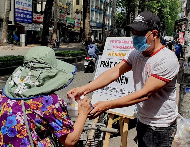 Phát cơm miễn phí cho người gặp khó khăn vì dịch bệnh - Ảnh: Pha Lê