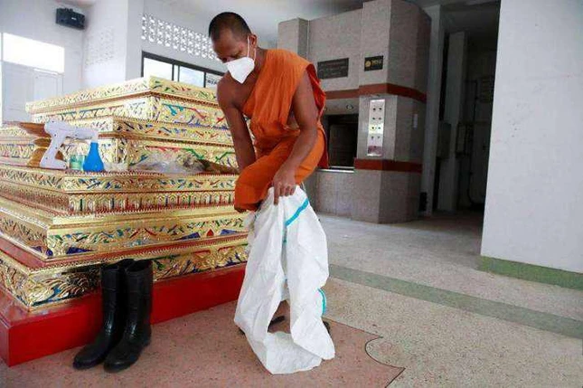 Sư Phra Pongpetch Santijittho mặc PPE để hỏa táng thi thể bệnh nhân Covid-19 tại một tu viện ở ngoại ô Bangkok