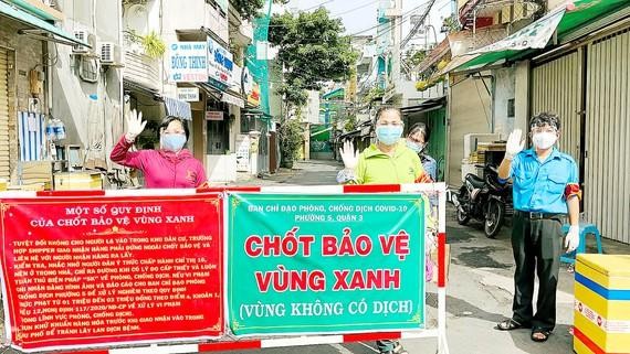 Nhân dân tự nguyện tham gia trực chốt tự quản bảo vệ “vùng xanh” ở quận 3 - Ảnh: Văn Minh