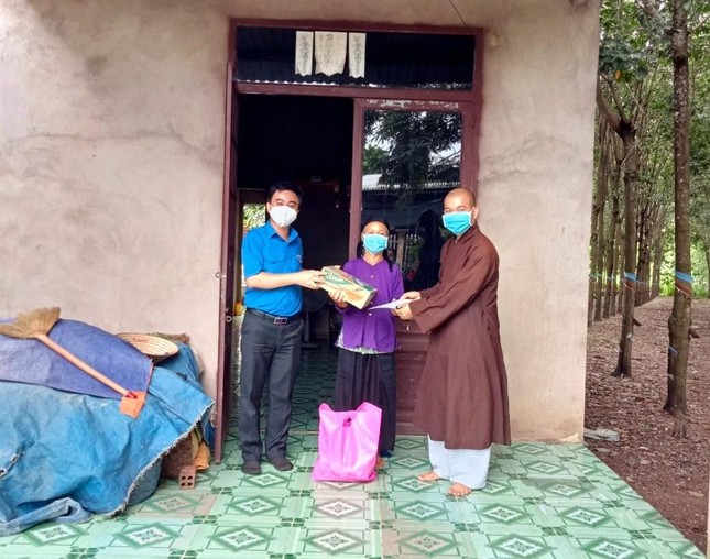 Phật tử Rê Thị Dinh nhận quà từ Bí thư Tỉnh Đoàn Trần Quốc Duy và Hòa thượng Thích Tâm Đăng, Trưởng ban Trị sự Phật giáo huyện Đồng Phú, trụ trì chùa Vạn Quang