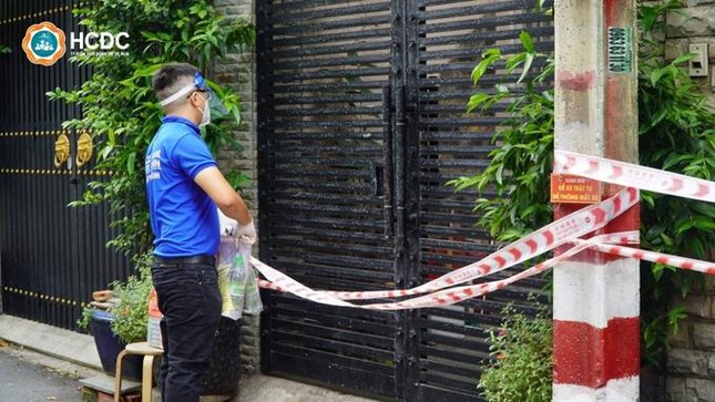 Nhân viên y tế đưa thuốc tới từng gia đình có F0, đảm bảo các quy định phòng chống dịch - Ảnh: HCDC