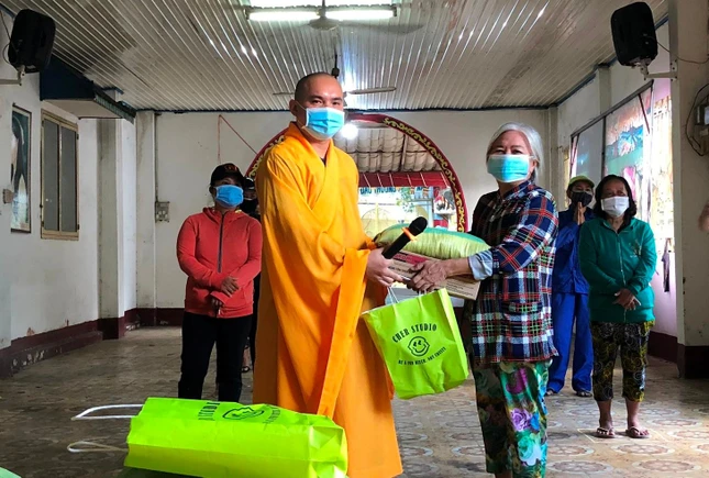 Đại đức Thích Huệ Đạo trao quà cho bà con