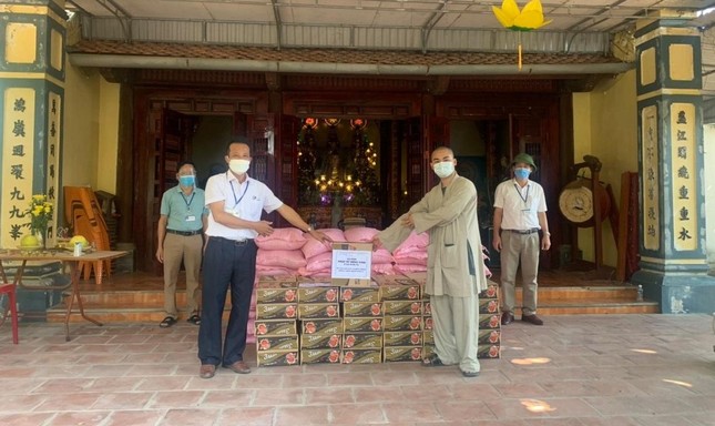 Đại đức Thích Nguyên Tâm, trụ trì chùa Vĩnh Phúc trao các nhu yếu phẩm cho lực lượng chống dịch xã Hưng Thịnh