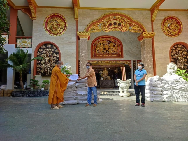 Đại đức Thích Thiện Tài trao biểu trưng quà tặng tới ông Nguyễn Ngọc Châu, Phó Chủ tịch Thường trực Ủy ban MTTQVN quận 3