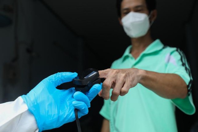 Nhân viên y tế phường Linh Tây (TP.Thủ Đức) thăm, khám và phát thuốc cho F0 điều trị tại nhà ngày 3-9 - Ảnh: Quỳnh Trần