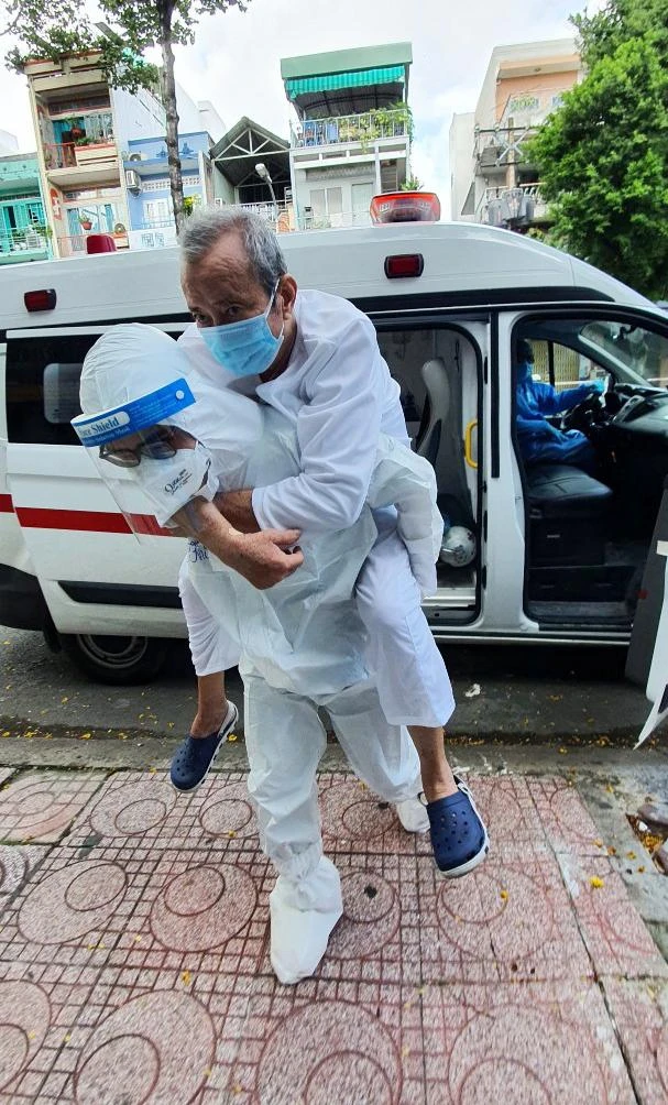 Tình nguyện viên tại Bệnh viện Hồi sức Covid-19 hỗ trợ đưa bệnh nhân về nhà